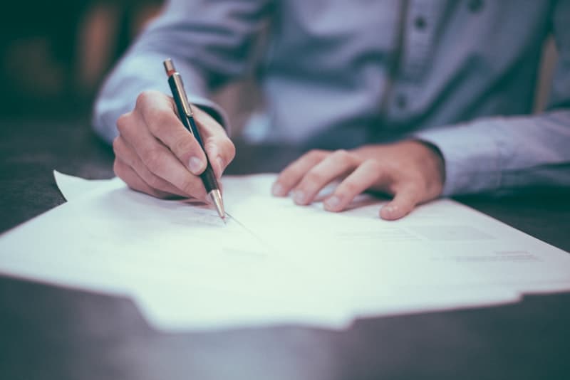 Ready to make an offer — create a free home purchase offer letter Person signing a home purchase offer letter after using a mortgage calculator